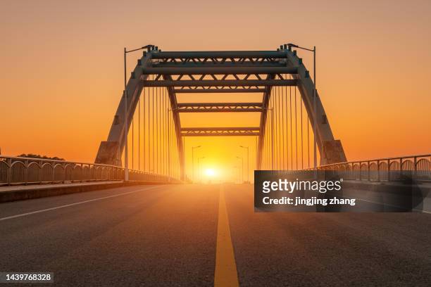 in the evening, the sun sets, and the high-speed kilometers through the arch bridge - dramatic sky perspective stock pictures, royalty-free photos & images