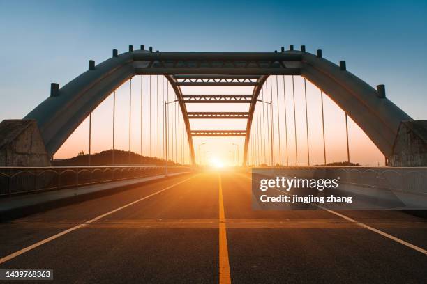 in the evening, the sun sets, and the high-speed kilometers through the arch bridge - brücke stock-fotos und bilder