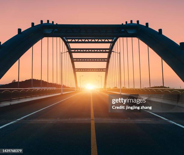 in the evening, the sun sets, and the high-speed kilometers through the arch bridge - ship's bridge imagens e fotografias de stock
