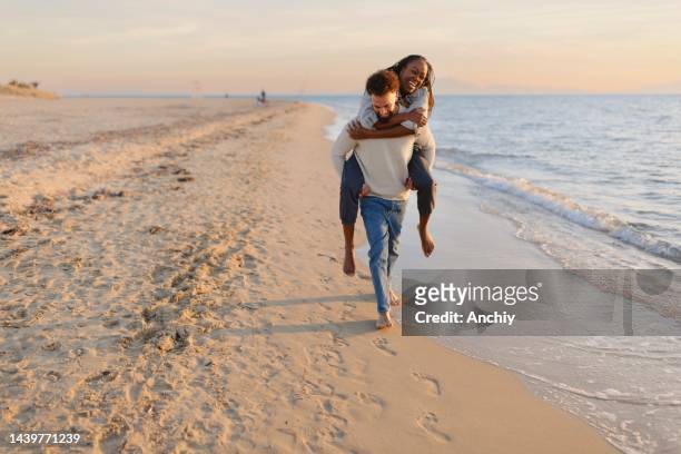 paar genießt einen tag am strand - romantic couple walking winter beach stock-fotos und bilder