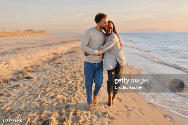 couple walking at beach during sunset - romantic couple walking winter beach stock pictures, royalty-free photos & images
