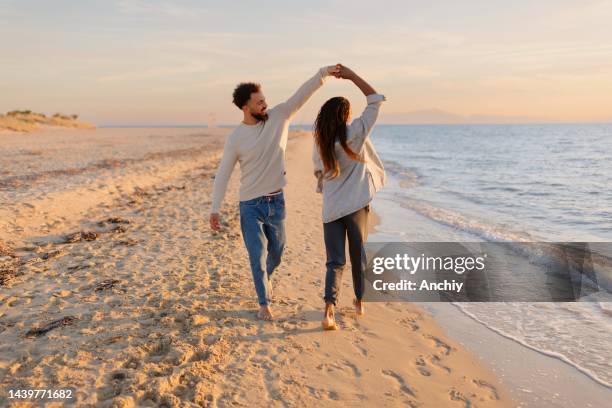 paar tanzt am strand - romantic couple walking winter beach stock-fotos und bilder