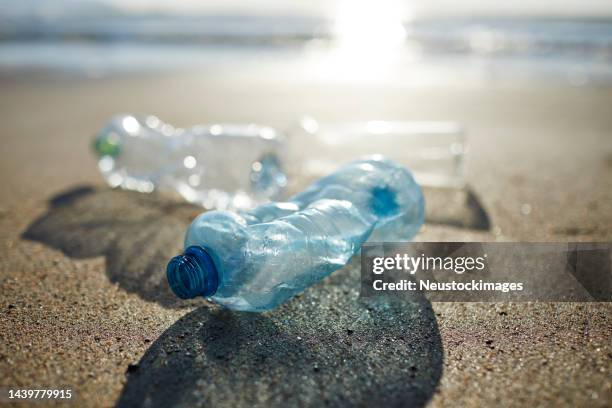 close-up of empty plastic bottles polluting beach - nature shallow depth of field stock pictures, royalty-free photos & images