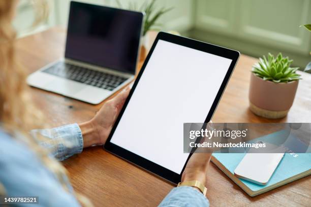 businesswoman holding tablet pc at table - blank screen stock pictures, royalty-free photos & images