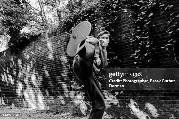 a young man standing and kicking - stomp stock pictures, royalty-free photos & images