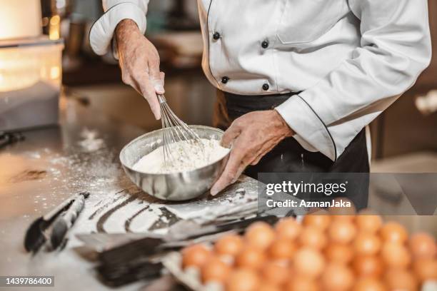 gros plan d’un boulanger caucasien mature mélangeant une pâte - baker smelling bread photos et images de collection