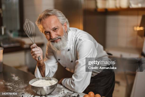 caucasian baker mixing a dough with a hand whisk in the kitchen - baker smelling bread stock pictures, royalty-free photos & images