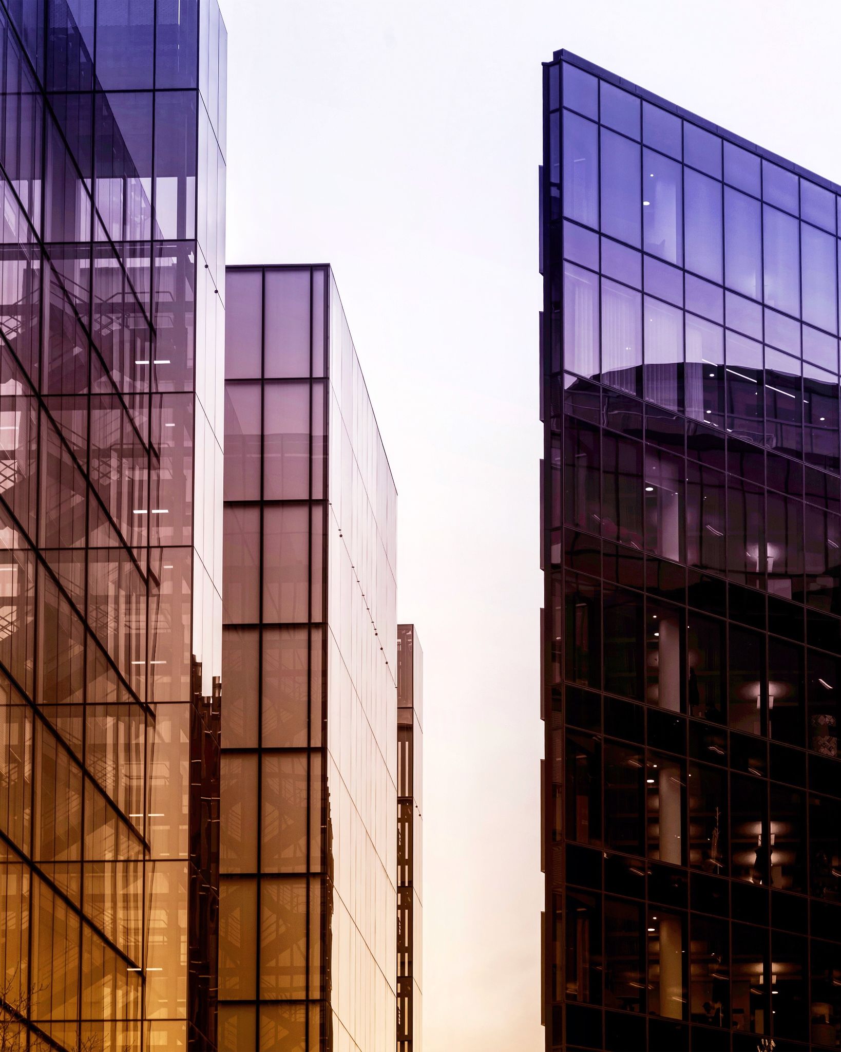 Vertical shot of high rise buildings in a glass facade with reflective windows Vertical shot of high rise buildings in a glass facade with reflective windows
