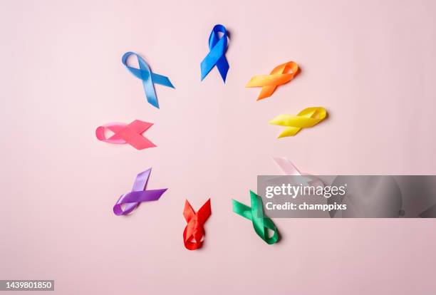 Multi colorful ribbons on pink background, cancer awareness, World cancer day, National cancer survivor day, world autism, supporting people living and illness, Prostate awareness concept.
