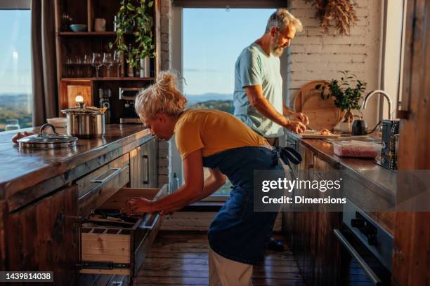 pareja mayor cocinando en apartamento. - family caucasian fotografías e imágenes de stock