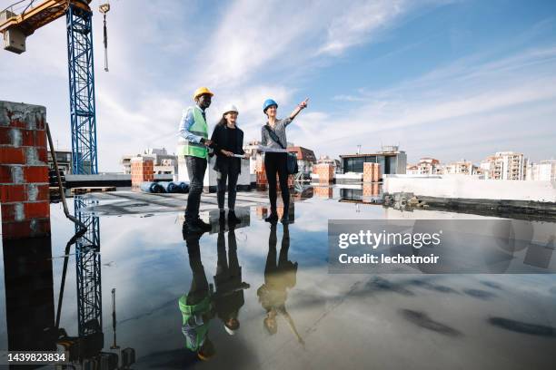 weibliche teamleiterin auf der baustelle - foundations conversations with suits stock-fotos und bilder