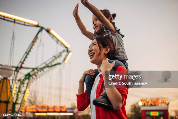 mom and daughter in amusement park - pretpark stockfoto's en -beelden