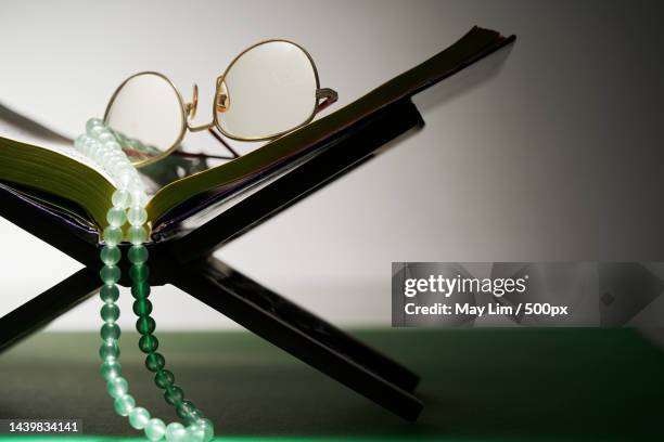 close up of koran and old reading glass - editorial photography stock pictures, royalty-free photos & images