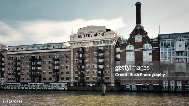 butler's wharf at shad thames on the south bank of the river thames, near london's tower bridge. london, england - shad stock pictures, royalty-free photos & images