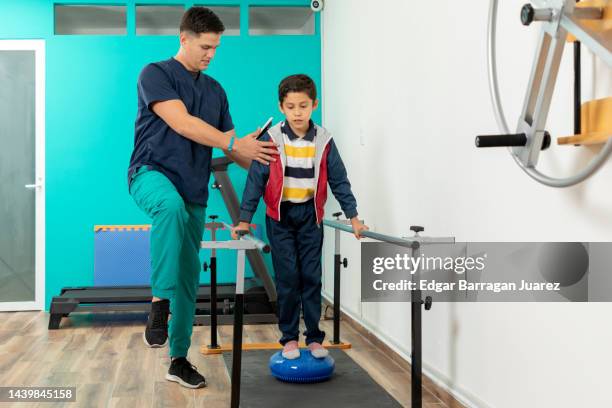 flat foot correction exercises with a ball to a child in a doctor's office - latina legs stock-fotos und bilder