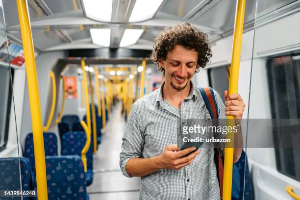 junger mann telefoniert in einer u-bahn in stockholm - öffentliches verkehrsmittel stock-fotos und bilder