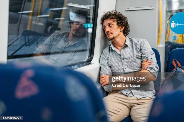 young man leaning on a window of a subway train in stockholm - pure stock pictures, royalty-free photos & images