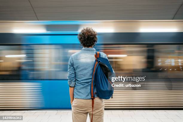 joven esperando un tren subterráneo en estocolmo - mochila-bolsa fotografías e imágenes de stock