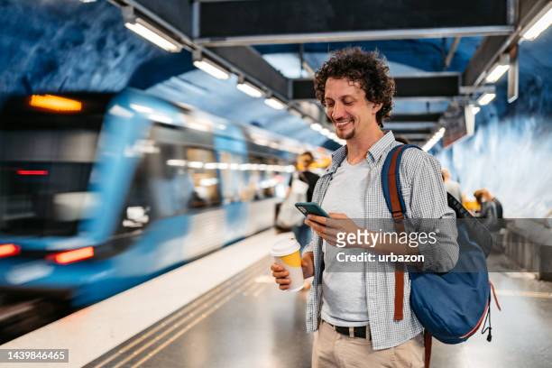 junger mann telefoniert, während er in stockholm auf eine u-bahn wartet - bahnreisender stock-fotos und bilder