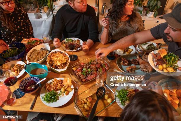 vista de ángulo alto de la mesa cargada en la cena de friendsgiving - potluck fotografías e imágenes de stock