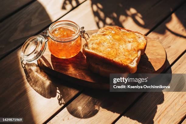 delicious toast with sweet jam on wooden board - marmelade stock-fotos und bilder