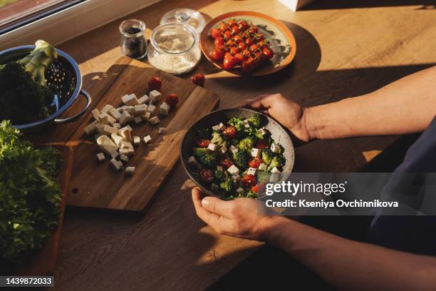 man's hand scooping green salad. healthy lifestyle and vegetarian vegan concept, intermittent fasting. - fasting stock pictures, royalty-free photos & images