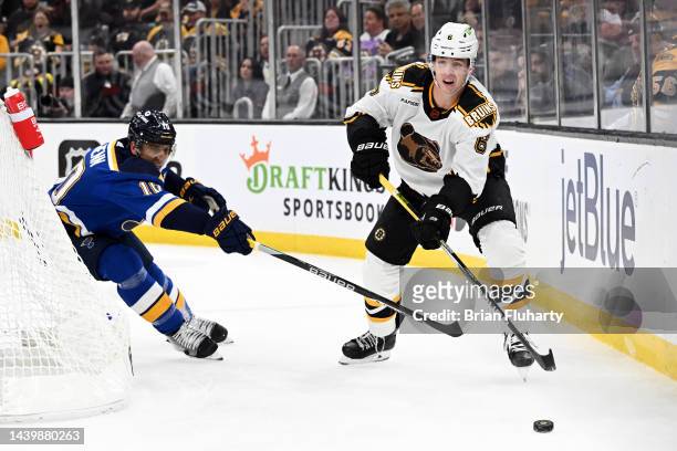 Mike Reilly of the Boston Bruins passes the puck as Brayden Schenn of the St. Louis Blues pursues the play during the second period at the TD Garden...