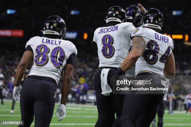 Lamar Jackson of the Baltimore Ravens celebrates with Isaiah Likely and teammates after throwing for a touchdown during the first quarter against the...