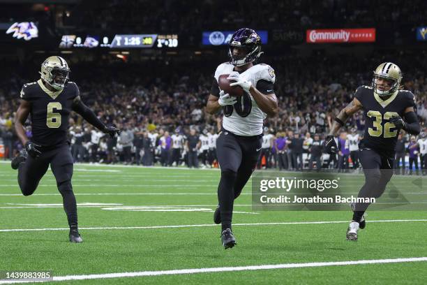 Isaiah Likely of the Baltimore Ravens catches a pass for a touchdown against Marcus Maye and Tyrann Mathieu of the New Orleans Saints during the...