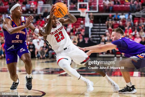 Guard De'Vion Harmon of the Texas Tech Red Raiders passes the ball against guards Ja'Monta Black and Isaac Haney of the Northwestern State Demons...