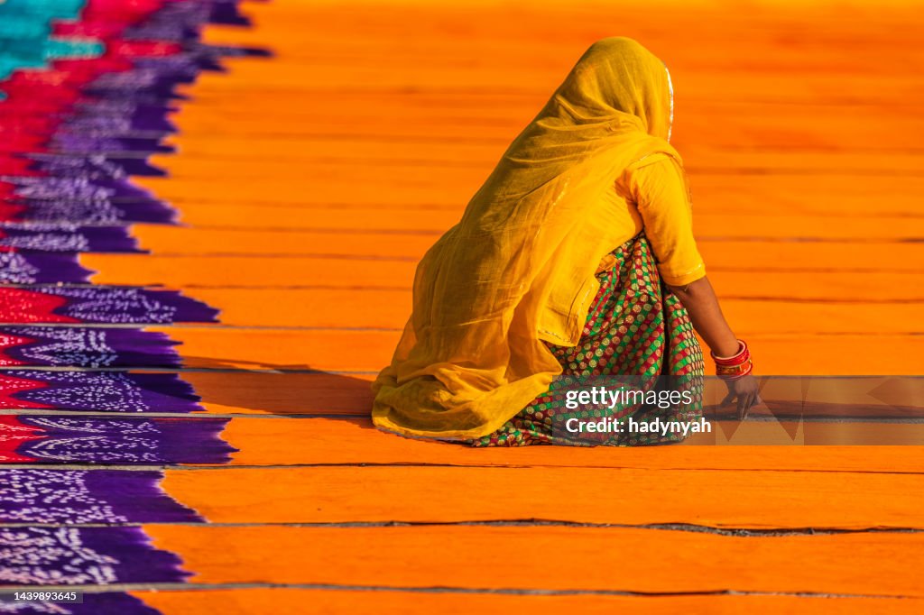 Colors of India - woman checking dyed fabrics, Rajasthan, India
