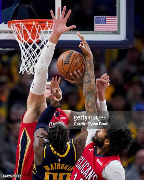 Bennedict Mathurin of the Indiana Pacers attempts a shot while being guarded by Jonas Valanciunas and Brandon Ingram of the New Orleans Pelicans in...