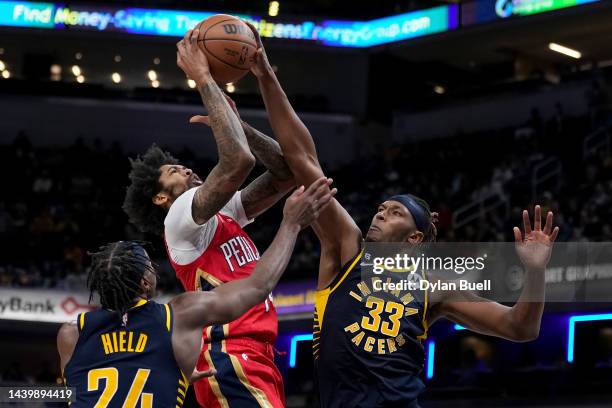 Brandon Ingram of the New Orleans Pelicans attempts a shot while being guarded by Buddy Hield and Myles Turner of the Indiana Pacers in the fourth...