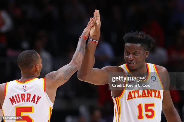 Clint Capela of the Atlanta Hawks reacts with Dejounte Murray after drawing a foul on a dunk against Grayson Allen of the Milwaukee Bucks during the...