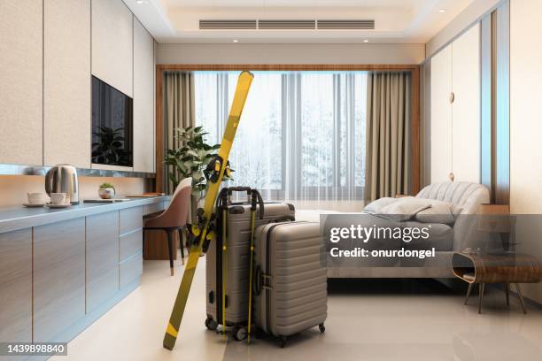 winter holiday concept. modern hotel room with luggages, ski, double bed, night tables, tv set and forest landscape from the window - ski closeup imagens e fotografias de stock