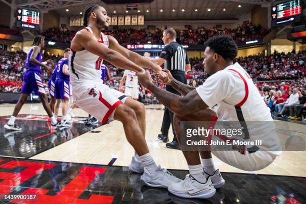Forward Kevin Obanor of the Texas Tech Red Raiders helps forward KJ Allen off the floor during the second half of the game against the Northwestern...