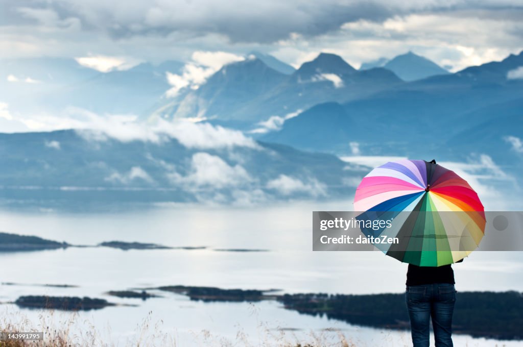 Woman with umbrella enjoying mountain view