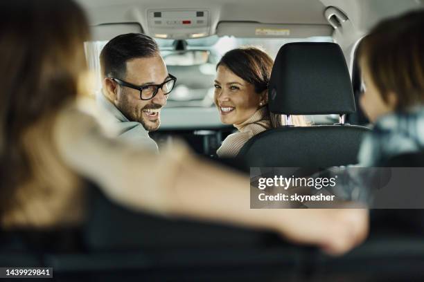 young happy family talking while going on a trip by car. - family inside car stockfoto's en -beelden