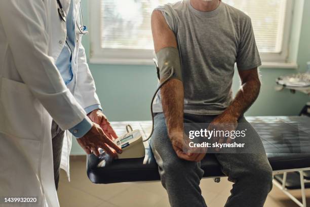 ¡medición de la presión arterial en el consultorio del médico! - hombre revision fotografías e imágenes de stock