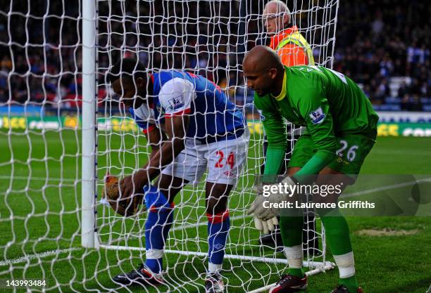 Yakubu of Blackburn Rovers and Ali Al Habsi of Wigan Athletic remove a chicken from the goal during the Barclays Premier League match between...