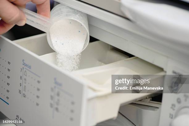 pouring washing powder in washing machine - producto de limpieza fotografías e imágenes de stock