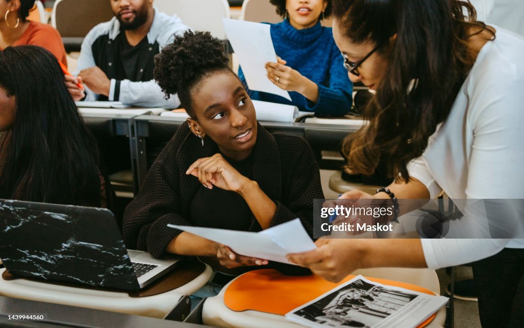 Female student and teacher discussing over test result in class