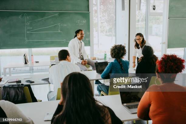 multiracial male and female students attending mathematics lecture in classroom - assistant professor photos et images de collection