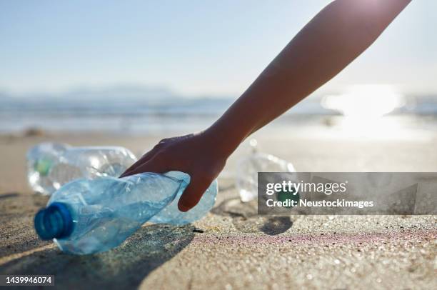 boy's hand picking up abandoned plastic bottles - children raising their hands stock pictures, royalty-free photos & images