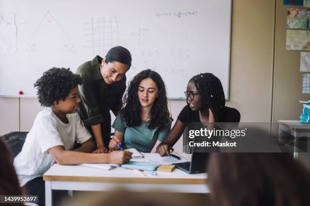 junior high students asking doubts to female teacher at desk in training class - high school students stock pictures, royalty-free photos & images