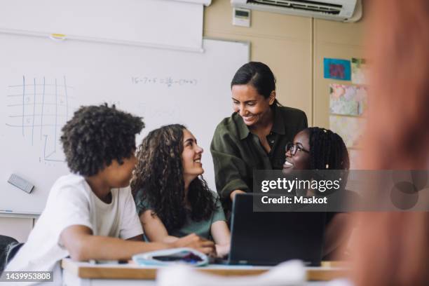 smiling female teacher talking with students in classroom at junior high school - education event stock pictures, royalty-free photos & images