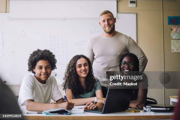 portrait of smiling professor and students in classroom at junior high school - portrait of teacher and student stock pictures, royalty-free photos & images