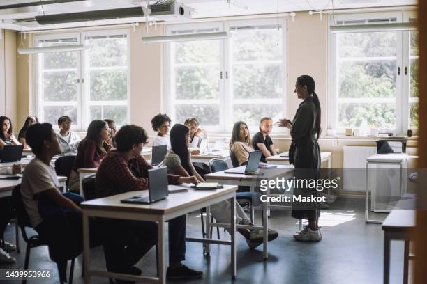 teacher explaining male and female students in classroom at junior high school - lehrer schüler stock-fotos und bilder