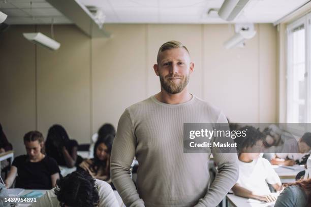 portrait of smiling male professor with students studying in background at school - sweden school stock pictures, royalty-free photos & images