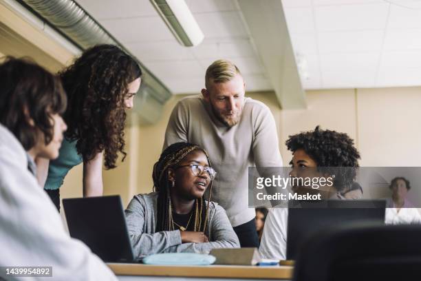 multiracial junior high students discussing by professor in class at school - black man high 5 stockfoto's en -beelden